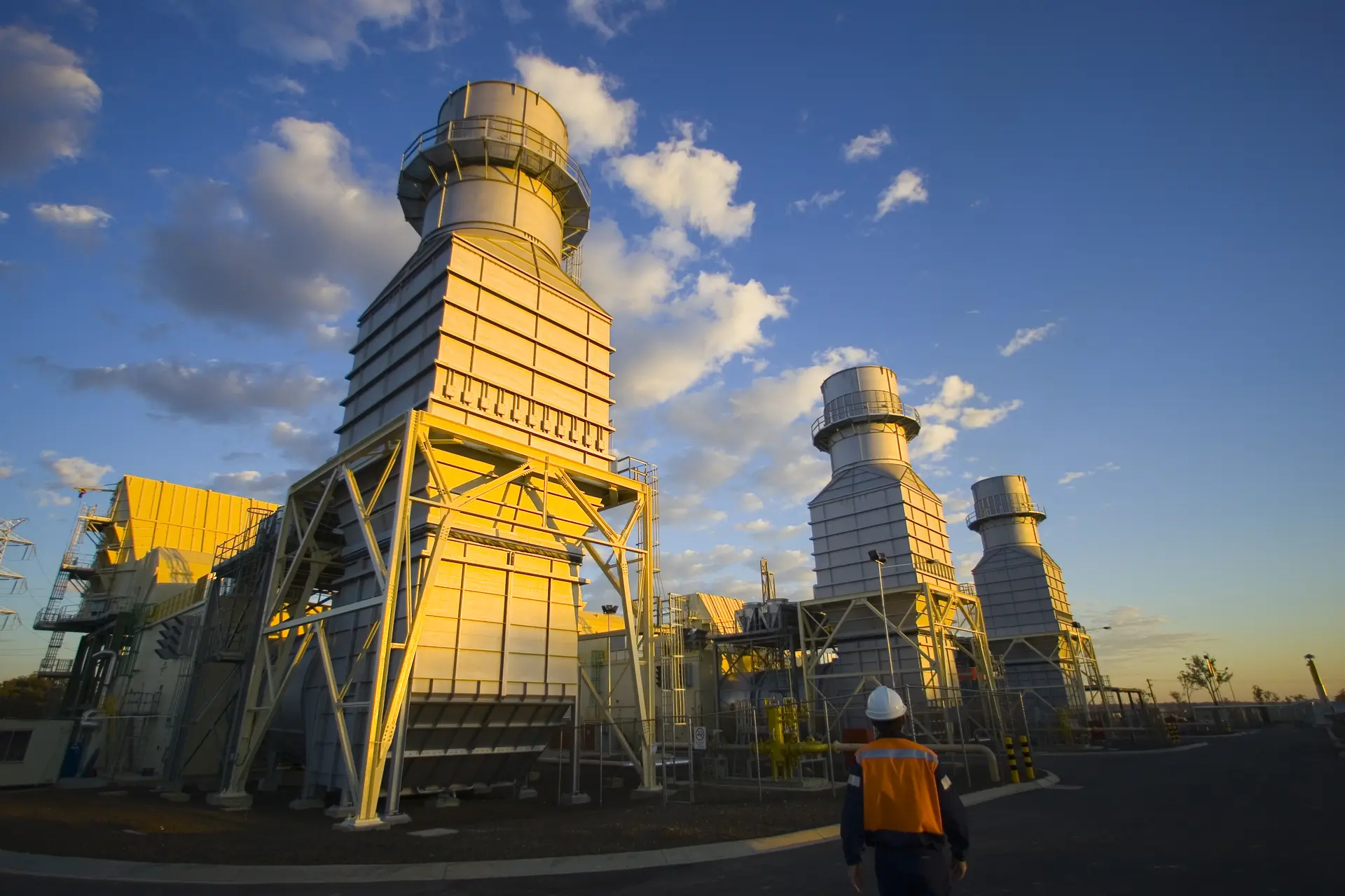 Three gas-turbine units at Braemar Power Station beneath a blue sky